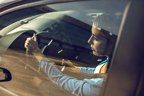 A Blacklane guest steps out of a black car with her chauffeur holding the door open.